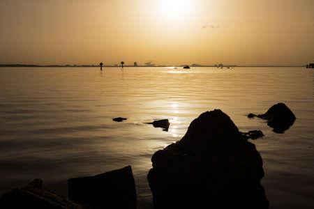 The calm sea gleaming under the shining, bright sunset