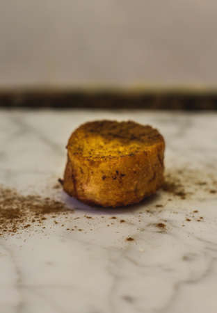 A closeup vertical shot of a single biscuit on a marble table