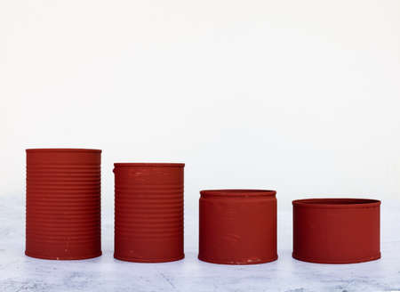 A closeup of red cans in different sizes isolated on a white backgroundの写真素材