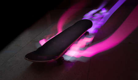 A timelapse shot of a skateboard with colorful light effects
