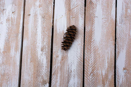 A closeup shot of a pine cone on wooden backgroundの写真素材