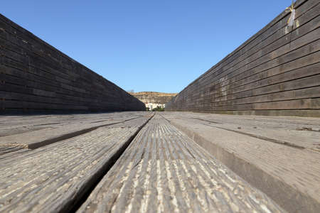 A closeup shot of a wooden bridge floor in the daylight