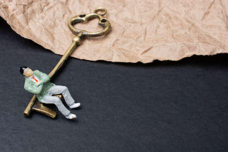 A closeup shot of a male figure on vintage key with crumpled vintage paperの写真素材
