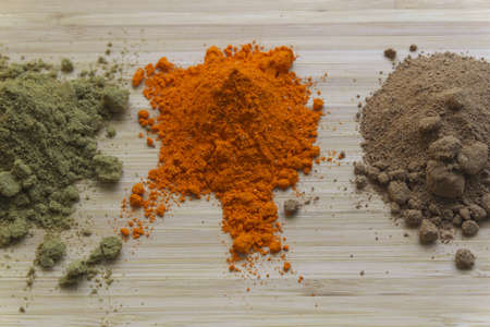 Three different types of spices are showed on a wooden tablet.の写真素材