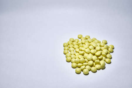 A closeup shot of yellow medical pills isolated on white background