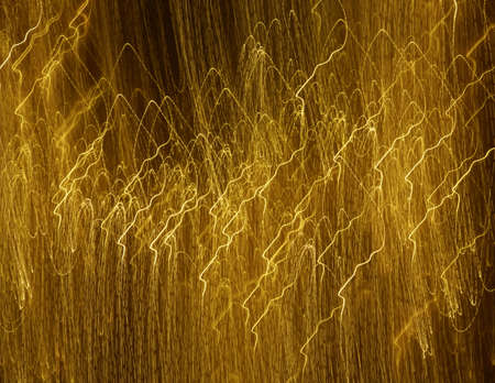 An illustration of golden lines on a dark background creating unique patternsの写真素材