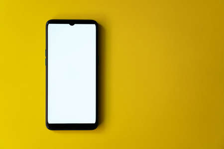 A smartphone isolated on a yellow backgroundの写真素材