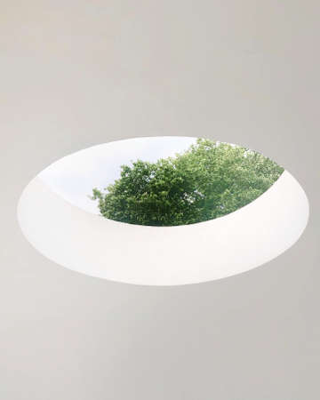 A big hole on the white ceiling with the clear sky and trees seen through it