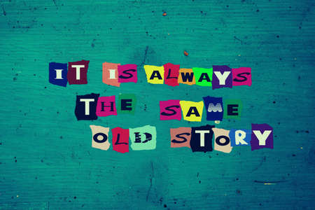 A rusty blue surface with colorful letters spelling out It is always the same old storyの写真素材