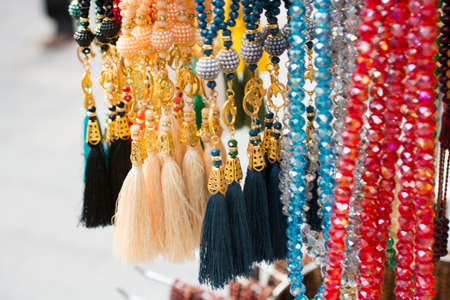 A closeup of colorful necklaces with beads in a store for saleの写真素材