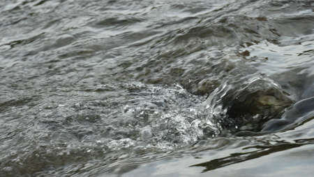 A horizontal closeup shot of tiny waves in a sea