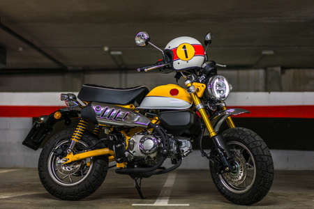 A horizontal shot of a yellow and black motorcycle in an underground parking