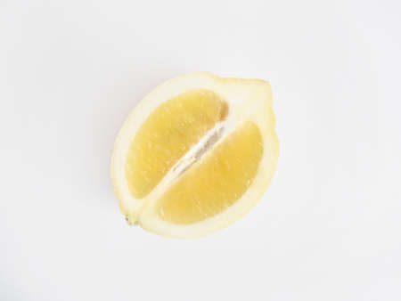 A closeup of a sliced yellow fresh lemon on a white background - perfect natural wallpaperの写真素材