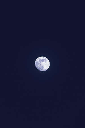 The beautiful lonely white moon in the dark blue skyの写真素材