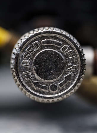 A closeup of a beer bottle metal cap with arrows and writing "closed" and "open" on it with a blurred backgroundの写真素材