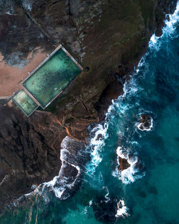Aerial shot of the sea and a sea pool at the coast of the cityの写真素材