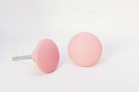 A closeup shot of pair of pink knobs isolated on a white background