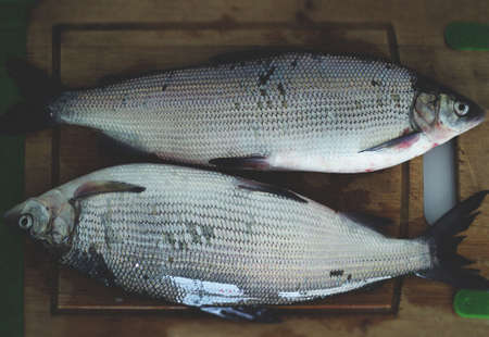2 fish on a wooden board for cooking