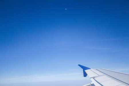 An airplane wing with beautiful clear blue sky shot from insideの写真素材
