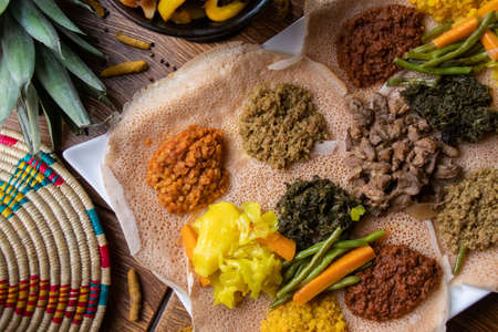 A high angle shot of the ingredients of traditional Ethiopian food on loaves of breadの写真素材