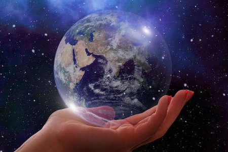 An illustration of a female hand holding the globe with a cosmic backgroundの写真素材