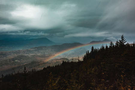 A beautiful wide shot of high rocky mountains and hills covered in natural fog during Winter time in the countrysideの写真素材