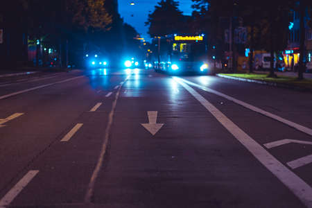 Buses and cars illuminate a city street at night. Busy traffic route in Munich during the dark...