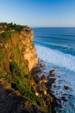 A vertical shot of Ulu Watu Cliffs in Indonesia under a clear blue skyの写真素材