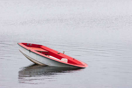 The old fishing boat sinking  at the seaの写真素材