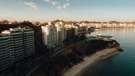 A beautiful landscape aerial shot of a coast with buildings in Rio de Janeiro during sunsetの写真素材