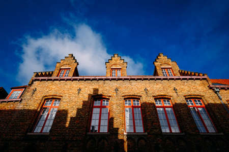 A low angle shot of a brown bricked made cathedral with windows at daytimeの写真素材