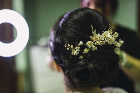 A close up shot of a bridal hairstyle on dark hair with white flowers