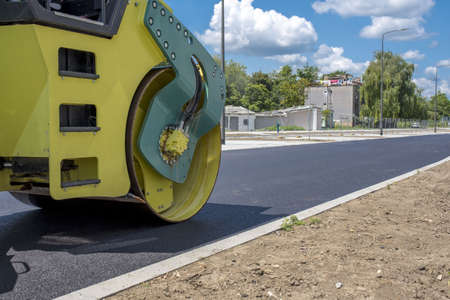 A closeup of a road-roller on the fresh asphalt at daytime