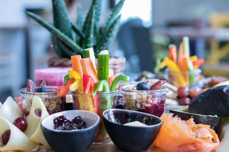 The delicious and various sliced fruits and veggies on a wooden boardの写真素材