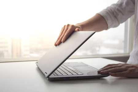 A man working from home on his laptop beside a bright window