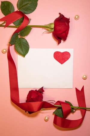 Red roses with a lovely envelope and pearls on a pink backgroundの写真素材