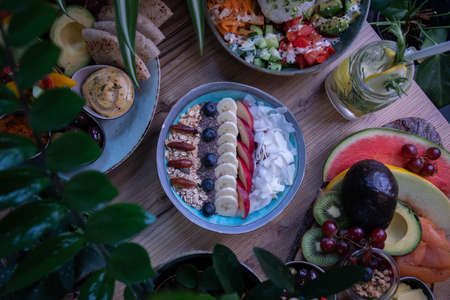 A high angle shot of a bowl with cereal and various  delicious fruitsの写真素材