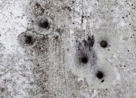 A closeup shot of bullet holes on an old rusted street signの写真素材