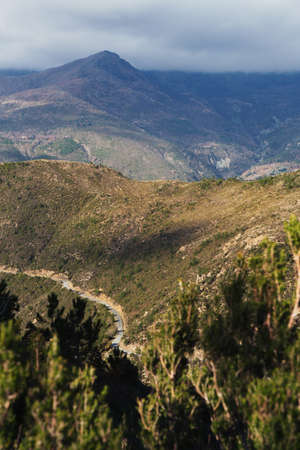 A vertical shot of green hills under the cloudy sky - perfect for a hiking conceptの写真素材