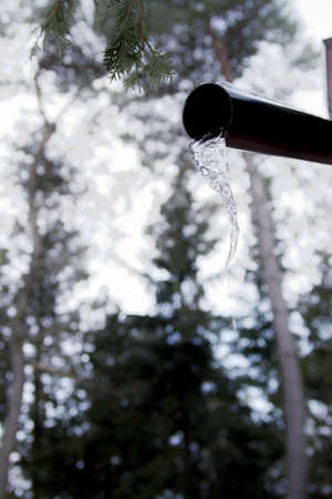 Frozen water under the pipe in the woods in Canada