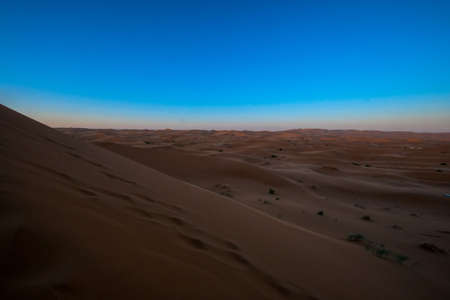 A beautiful shot of sand dunes with a clear blue sky in the background