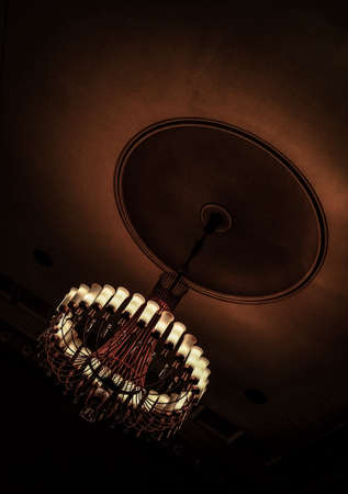 A vertical shot of a switched on chandelier with a dark background
