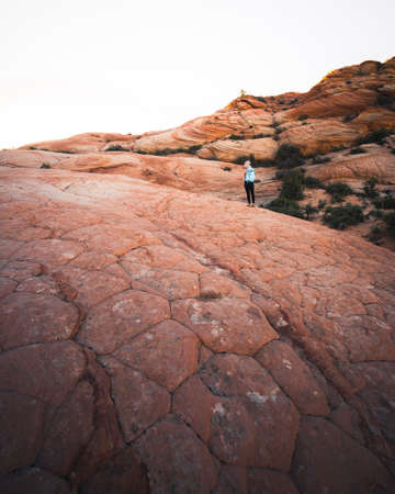 A female hiker with a backpack on a rocky desert hillsの写真素材