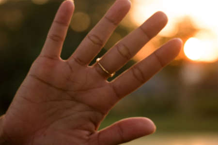 A blurred shot of a female open hand palm with a golden ring on the fingerの写真素材