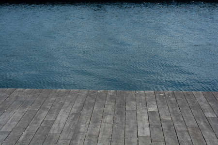 A high angle shot of a wooden dock by the lake at daytimeの写真素材
