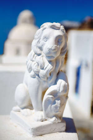 A vertical shot of a statue of a lion in a village in Santorini island, Greece on a sunny dayの写真素材