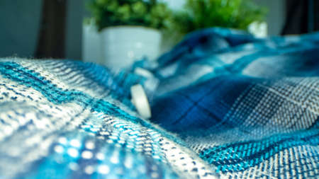 A closeup shot of blue fabric and blurred white button on background