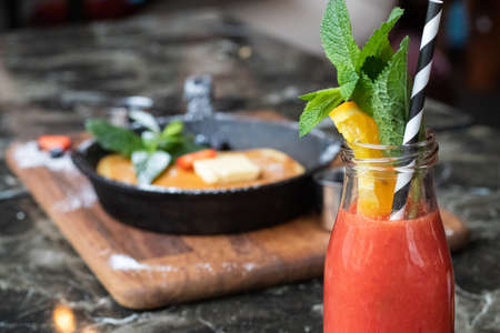 The delicious and fresh smoothie in the glass jar with a lemon ad a paper eco strawの写真素材