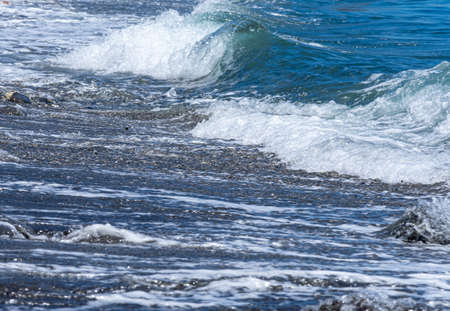 A beautiful scene of splashing waves on seashore under the sunlight