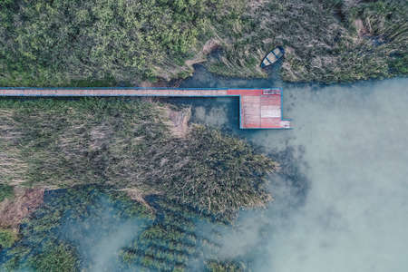 An overhead aerial shot of a small fishing spot near a lake